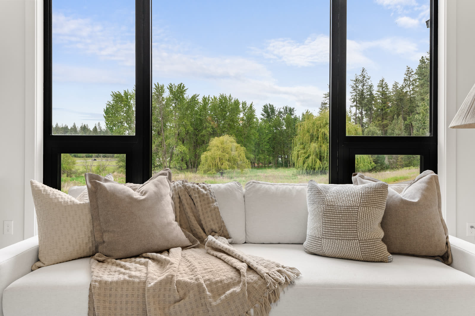 Bedroom window framing a North Idaho forest view