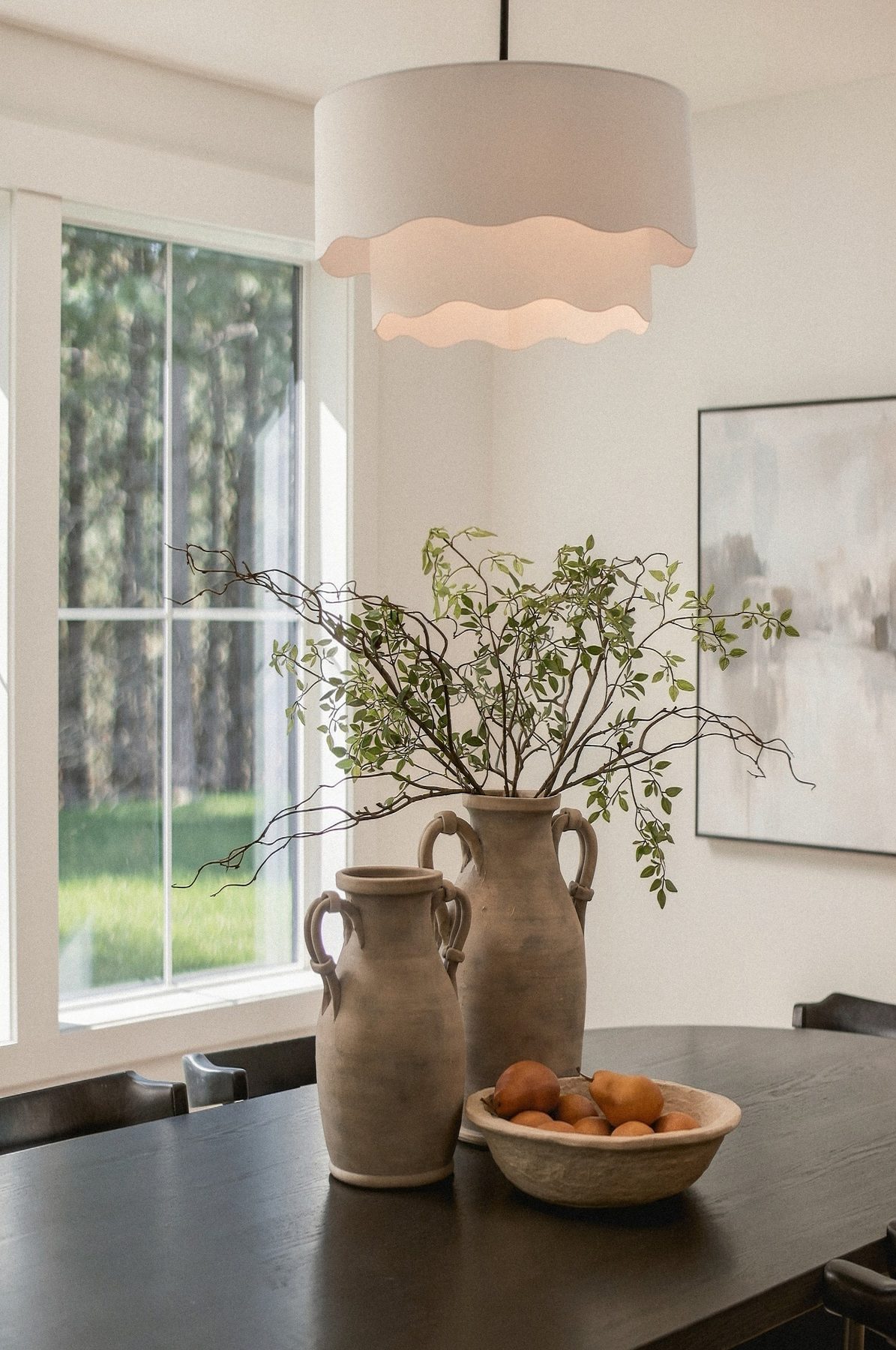 Styled dining table with a stoneware vase and fruit bowl
