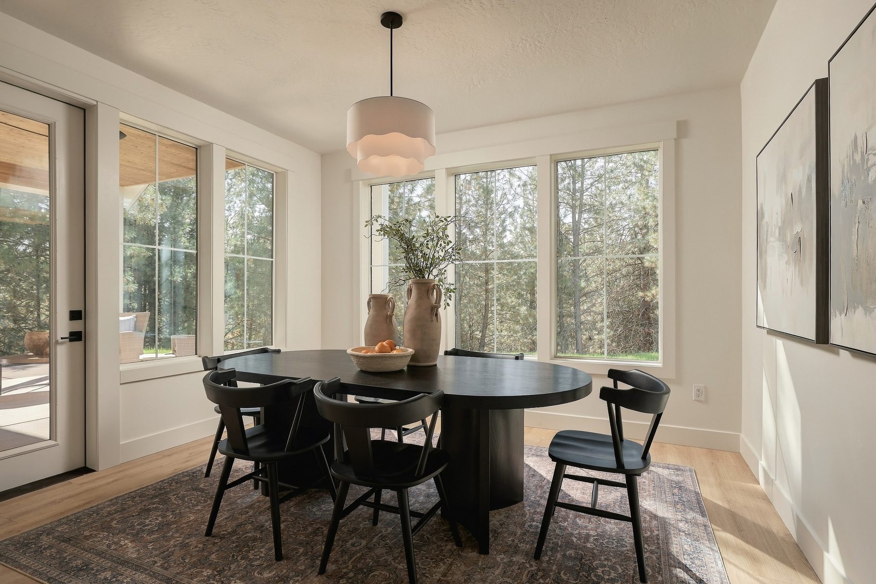 Dining nook with a round black table and wall of windows