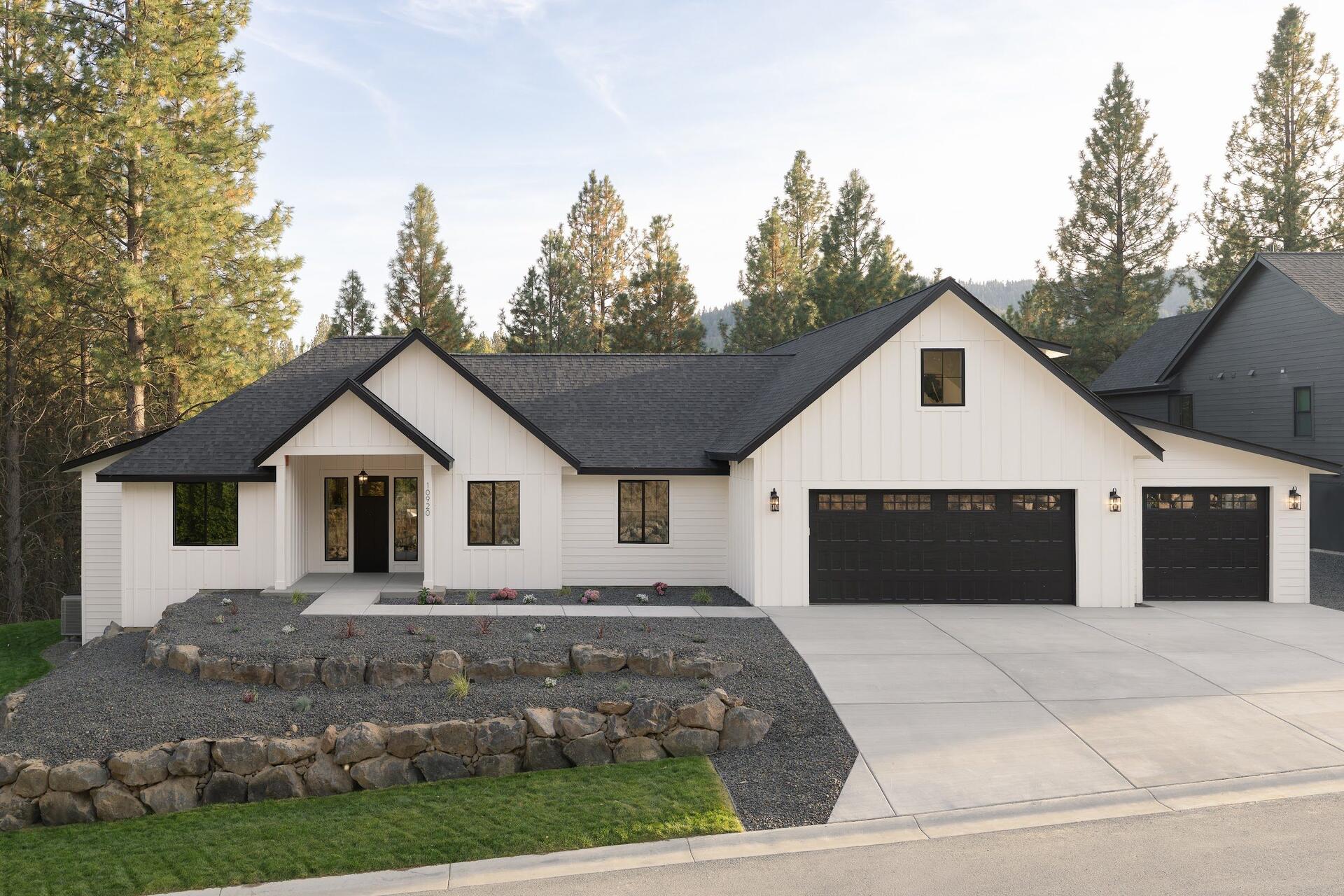 Ponderosa Peak, Elk Run's People's Choice Award-winning show home: a white board-and-batten farmhouse framed by pines in Spokane Valley