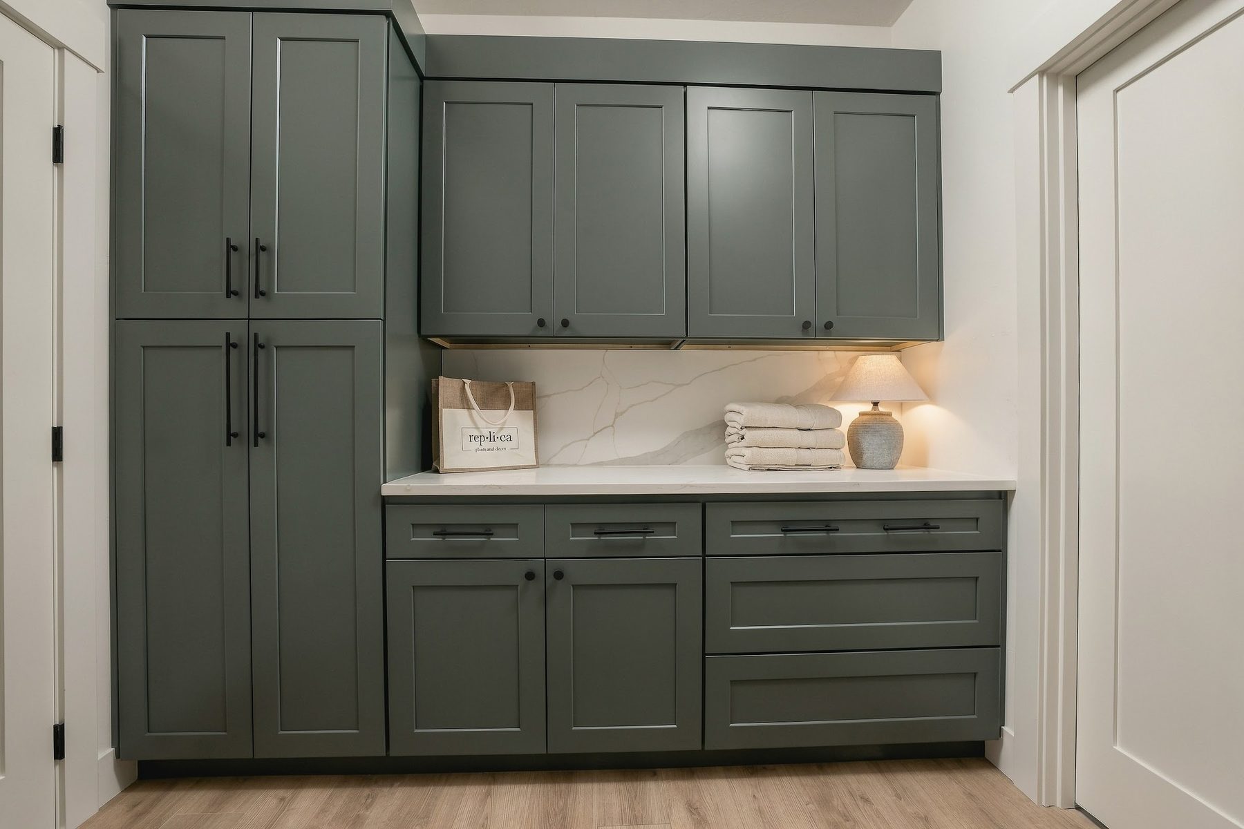 Laundry room with deep green cabinetry and folding counter