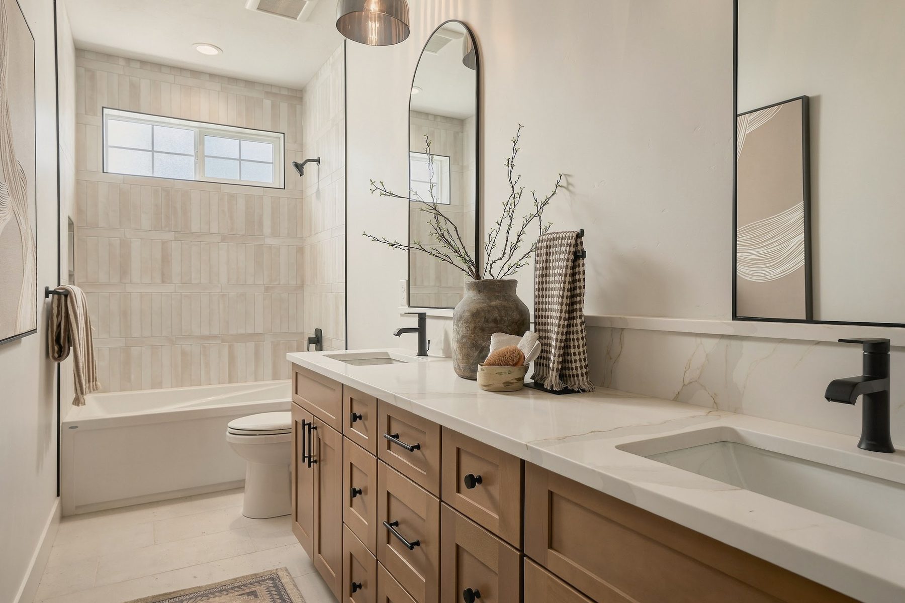 Primary bathroom double vanity with arched mirrors and tiled shower