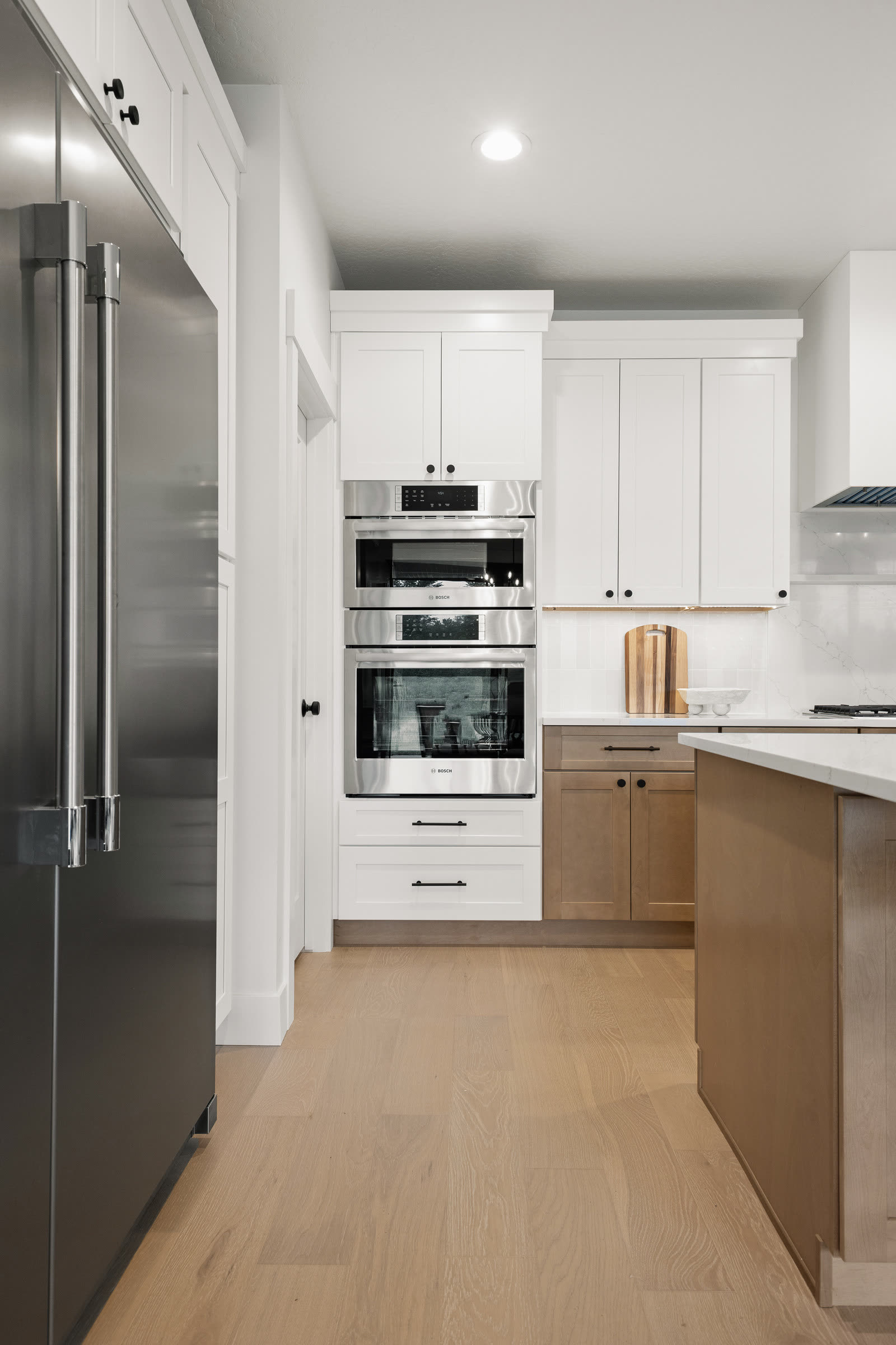 White oak kitchen cabinetry with integrated wall ovens